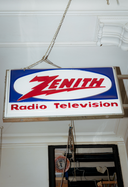A second-hand store in Barcelona. Sign: white background, blue background with white oval cut-out. Red text in middle of oval: ZENITH. Below, "Radio Television"